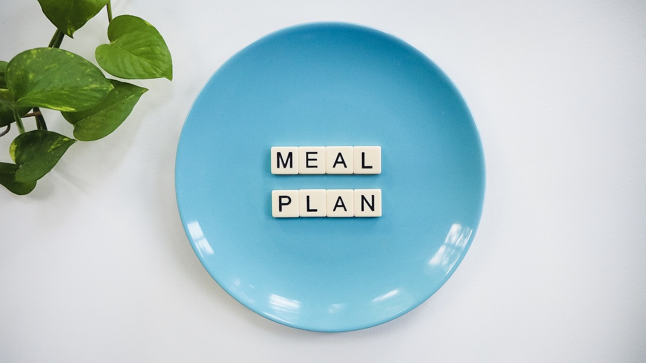 blauer Teller auf dem mit Buchstaben "meal plan" steht blauer Teller auf dem mit Buchstaben "meal plan" steht